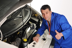 Mechanic inspecting the engine of a car.