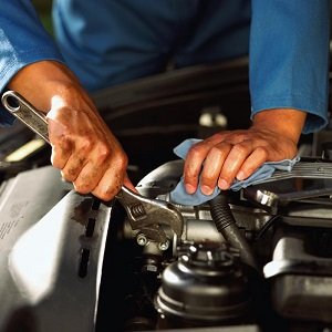 Mechanic inspecting the engine of a car.