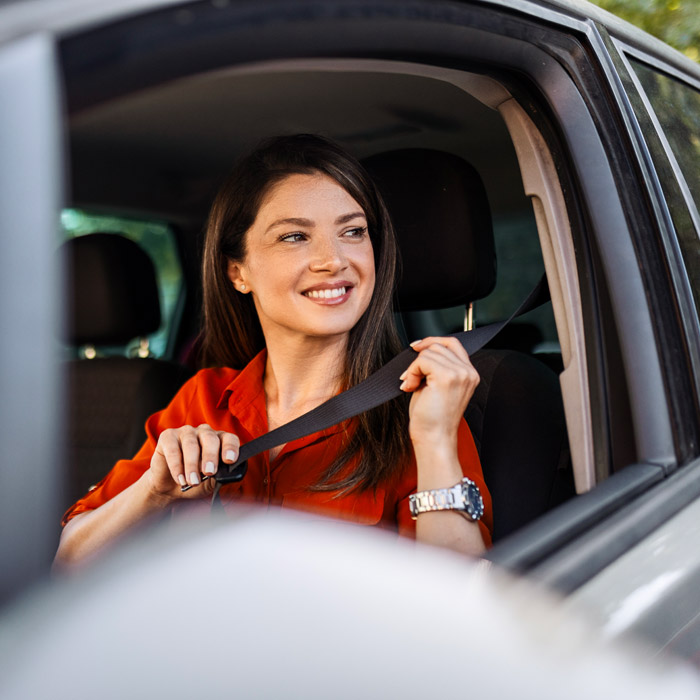 woman putting seatbelt on in car