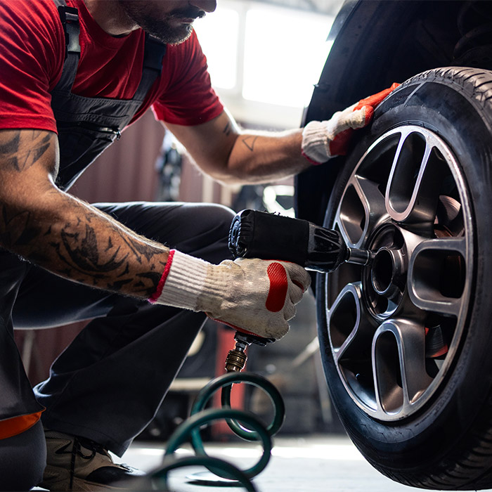 employee putting tire back on car