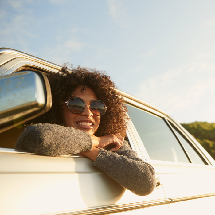 woman with head out of car window