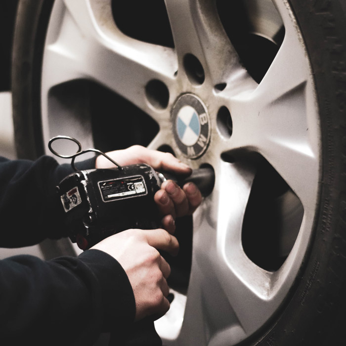 mechanic putting tire back onto car