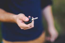 Person holding a car key in hand.