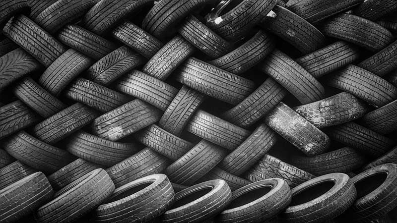 Pile of used car tires arranged in a pattern