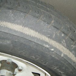 Close-up of a worn car tire showing tread wear